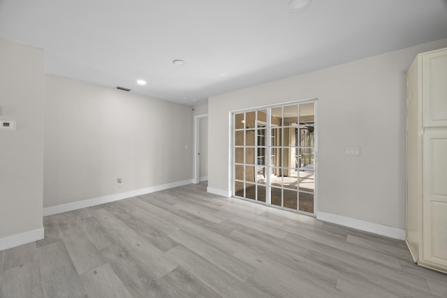 empty room with light wood-type flooring, visible vents, baseboards, and recessed lighting