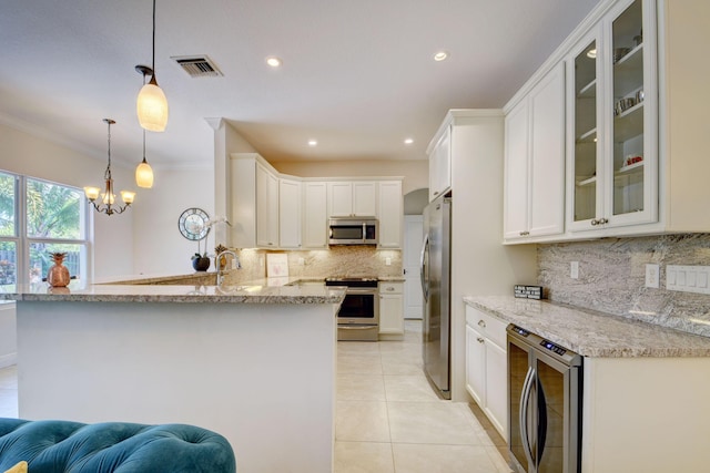 kitchen featuring light tile patterned floors, visible vents, glass insert cabinets, a peninsula, and stainless steel appliances