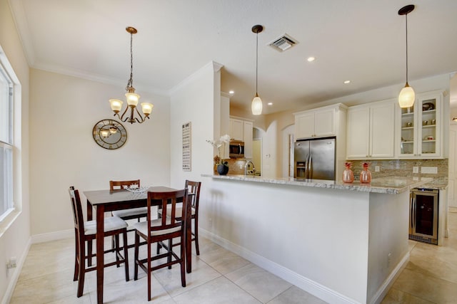 kitchen featuring wine cooler, visible vents, appliances with stainless steel finishes, backsplash, and glass insert cabinets