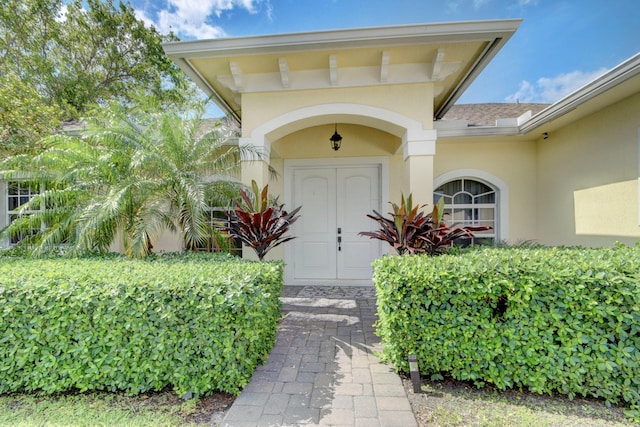 view of exterior entry featuring stucco siding