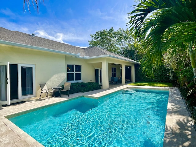 outdoor pool with a patio and a ceiling fan