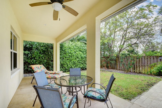 view of patio / terrace featuring fence, a ceiling fan, and outdoor dining space