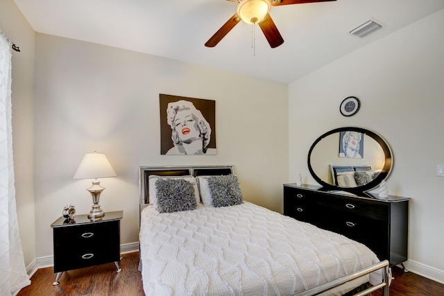 bedroom with a ceiling fan, wood finished floors, visible vents, and baseboards