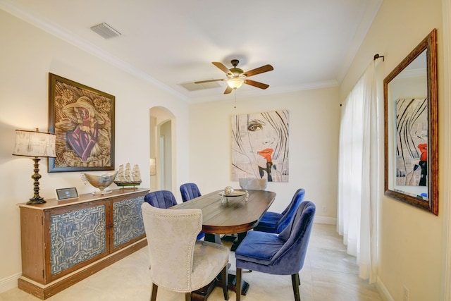 dining room featuring baseboards, visible vents, arched walkways, a ceiling fan, and crown molding