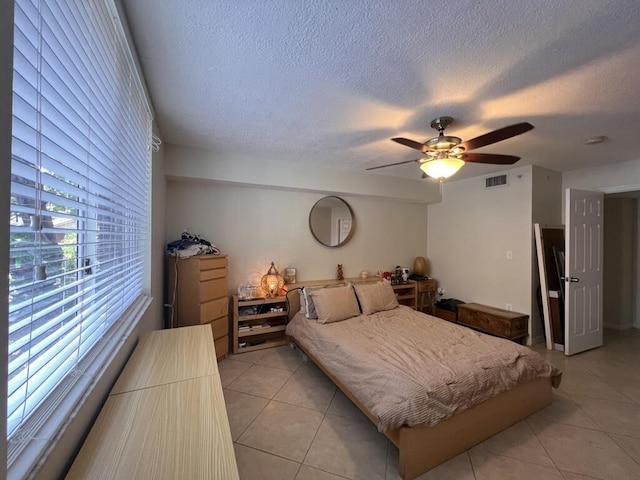 700 Scotia Dr Unit 103, Hypoluxo, FL 33462 - bedroom with a textured ceiling, ceiling fan, light tile patterned flooring, and visible vents