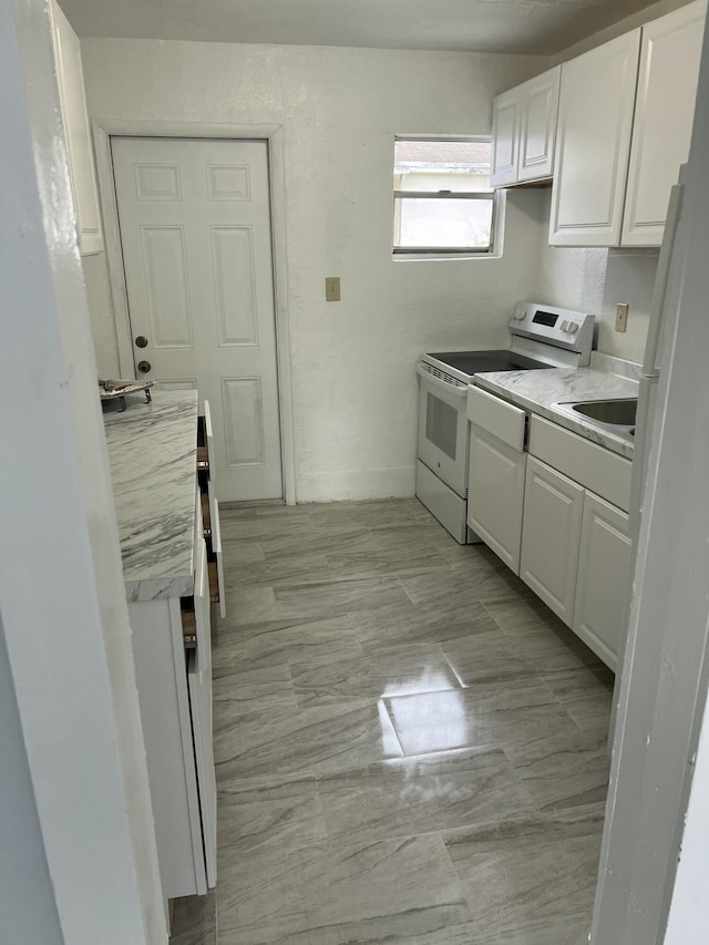 kitchen featuring a sink, white cabinets, electric stove, and light countertops