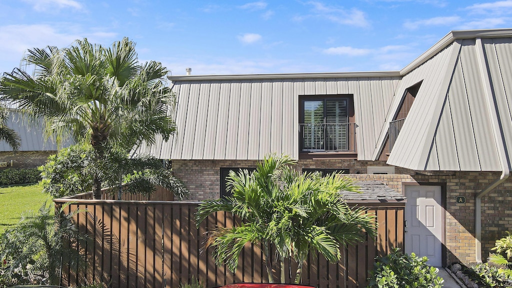view of home's exterior with brick siding and fence