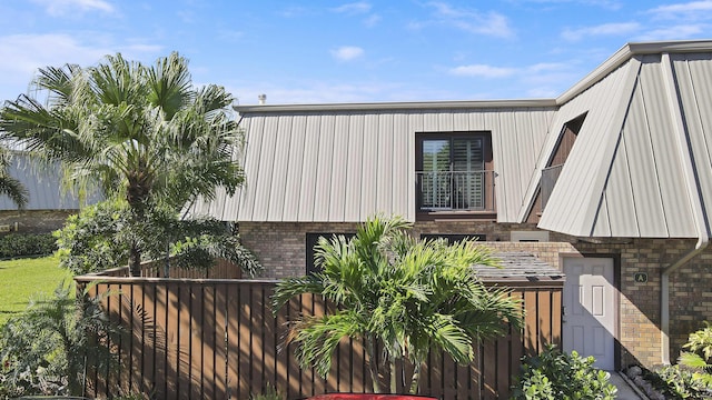 view of home's exterior with brick siding and fence