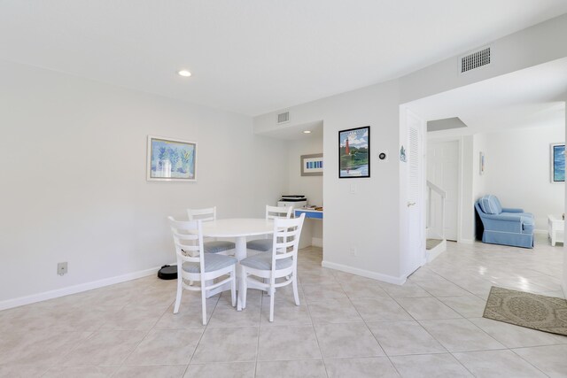 dining space featuring light tile patterned floors, visible vents, and baseboards