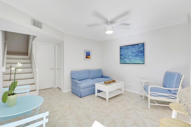 living area featuring visible vents, baseboards, ceiling fan, stairs, and light tile patterned floors