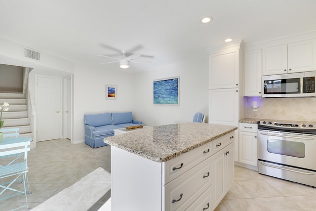 kitchen with visible vents, light stone counters, tasteful backsplash, stainless steel appliances, and light tile patterned floors