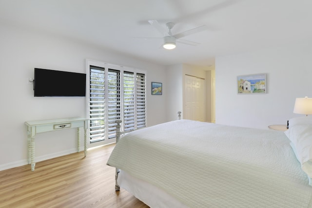 bedroom featuring baseboards, wood finished floors, and a ceiling fan