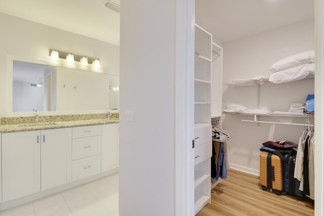 full bath featuring a sink, a spacious closet, and double vanity