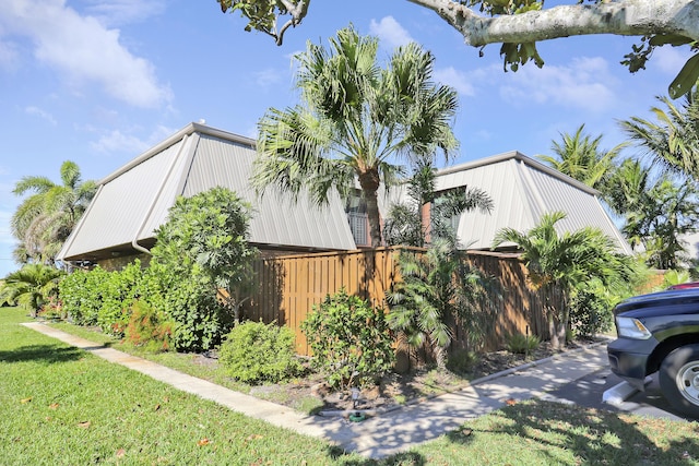 view of side of property with a lawn and fence