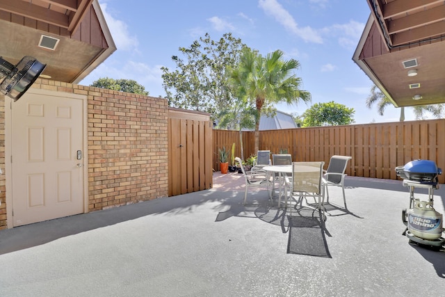 view of patio with outdoor dining area, a grill, and a fenced backyard