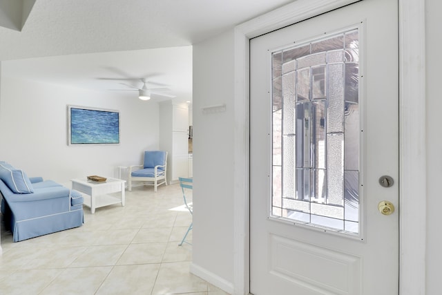 entryway featuring light tile patterned floors, baseboards, and a ceiling fan