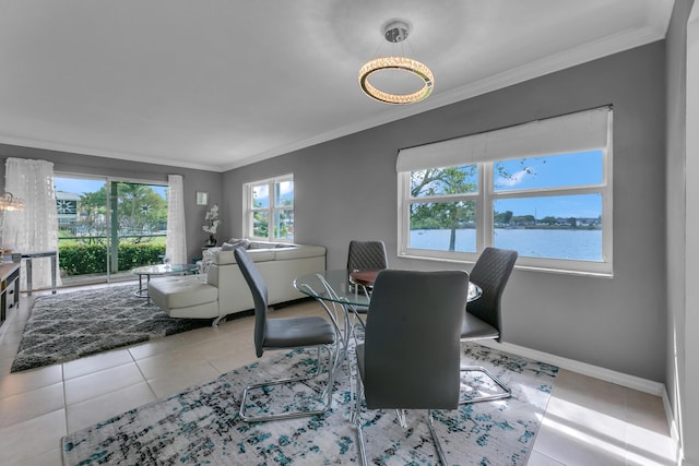 dining area with crown molding, baseboards, a water view, and tile patterned floors