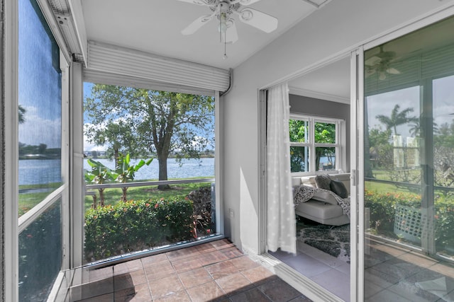 sunroom / solarium featuring a water view and a ceiling fan