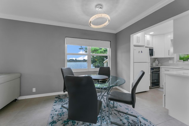 dining area with light tile patterned floors, ornamental molding, a water view, and baseboards