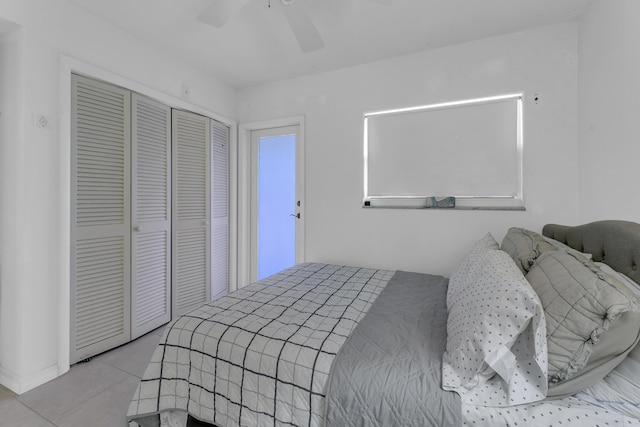 tiled bedroom featuring a ceiling fan and a closet