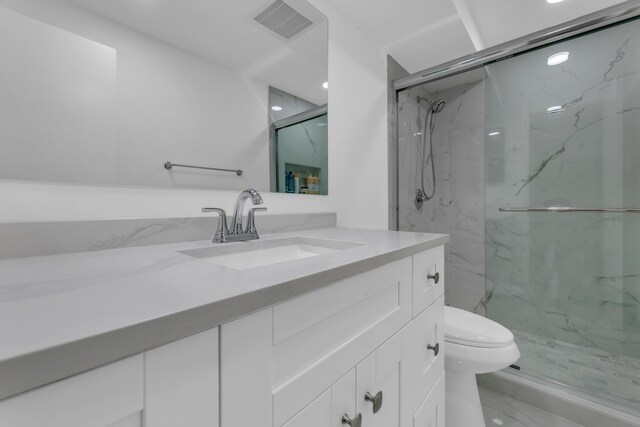 full bathroom featuring marble finish floor, a marble finish shower, visible vents, toilet, and vanity