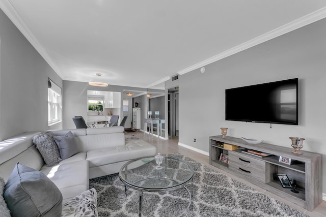 living room with visible vents, crown molding, and baseboards