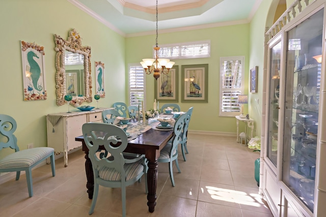 dining space featuring light tile patterned floors, baseboards, a raised ceiling, an inviting chandelier, and crown molding