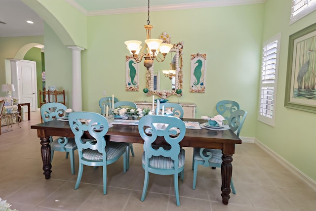 tiled dining area featuring baseboards, arched walkways, ornamental molding, ornate columns, and a chandelier