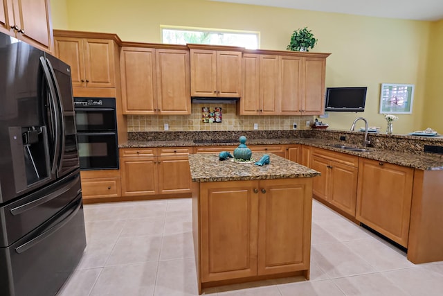 kitchen with tasteful backsplash, a sink, black appliances, and light tile patterned floors