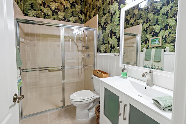 full bath with toilet, wallpapered walls, a stall shower, and wainscoting