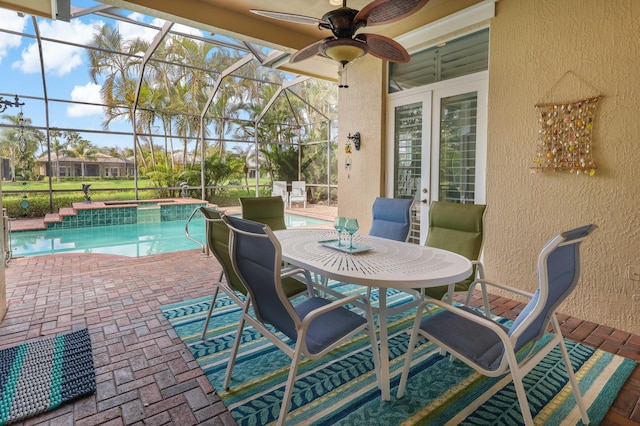 view of patio / terrace with ceiling fan, outdoor dining space, a lanai, and a pool with connected hot tub