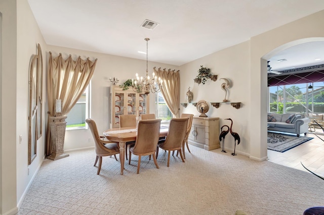 dining space featuring baseboards, plenty of natural light, visible vents, and a notable chandelier