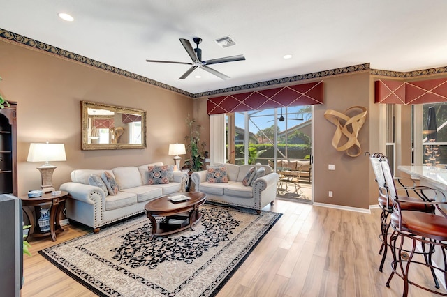 living area with recessed lighting, visible vents, light wood-style floors, a ceiling fan, and baseboards