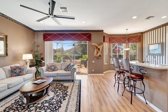 living area featuring light wood-style flooring, visible vents, baseboards, and recessed lighting