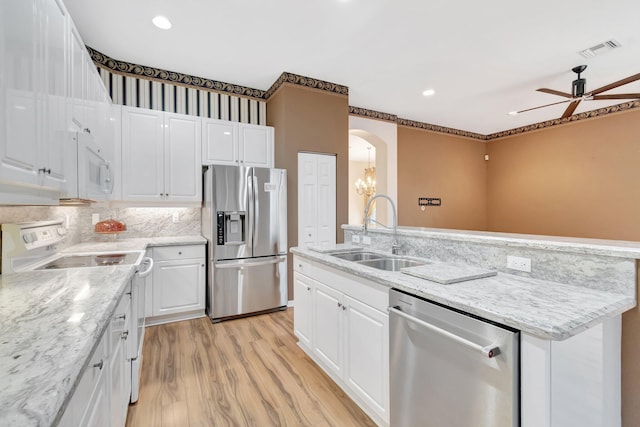 kitchen with stainless steel appliances, a sink, ceiling fan, white cabinetry, and light wood-type flooring