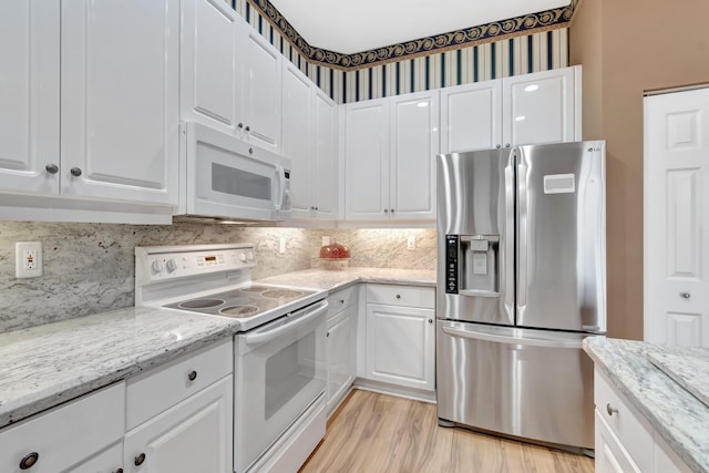 kitchen with white appliances, white cabinetry, light wood-style flooring, and tasteful backsplash