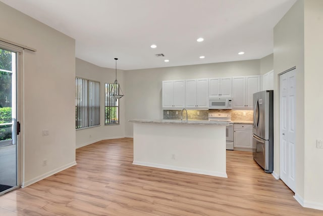7314 Toscane Ct, Boynton Beach, FL 33437 - kitchen with white appliances, light wood-type flooring, white cabinets, tasteful backsplash, and recessed lighting