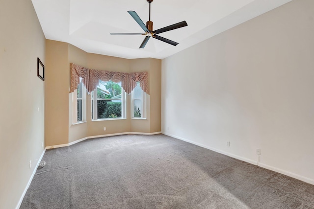 carpeted empty room featuring a ceiling fan and baseboards