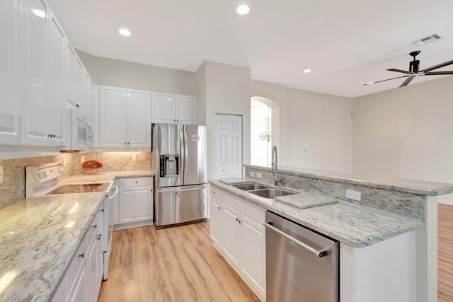 7314 Toscane Ct, Boynton Beach, FL 33437 - kitchen featuring appliances with stainless steel finishes, light wood finished floors, a sink, arched walkways, and recessed lighting