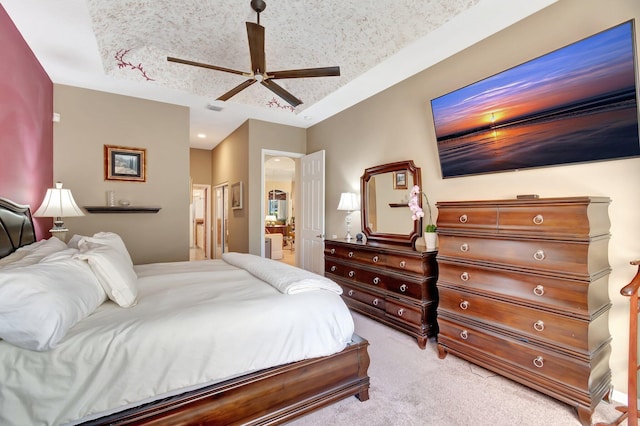 bedroom with a textured ceiling, connected bathroom, light carpet, visible vents, and a ceiling fan