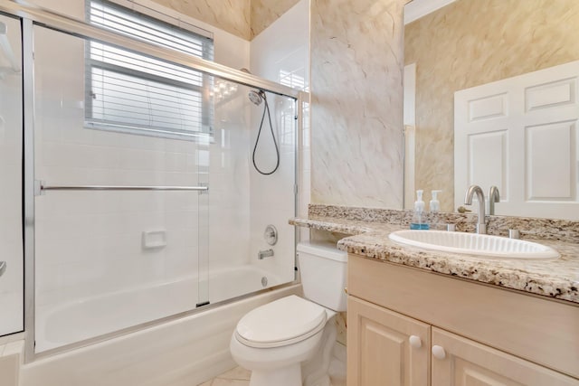 bathroom with toilet, combined bath / shower with glass door, and vanity