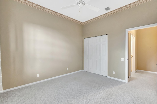 unfurnished bedroom with light colored carpet, baseboards, and a closet