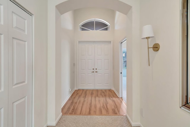 7314 Toscane Ct, Boynton Beach, FL 33437 - entrance foyer featuring baseboards, arched walkways, wood finished floors, and carpet