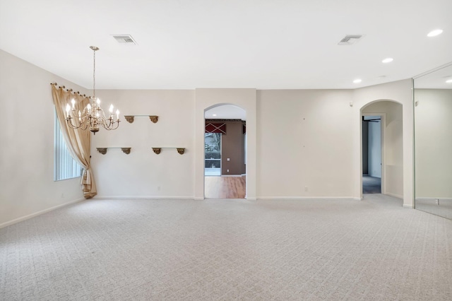 unfurnished room with arched walkways, light carpet, baseboards, and recessed lighting