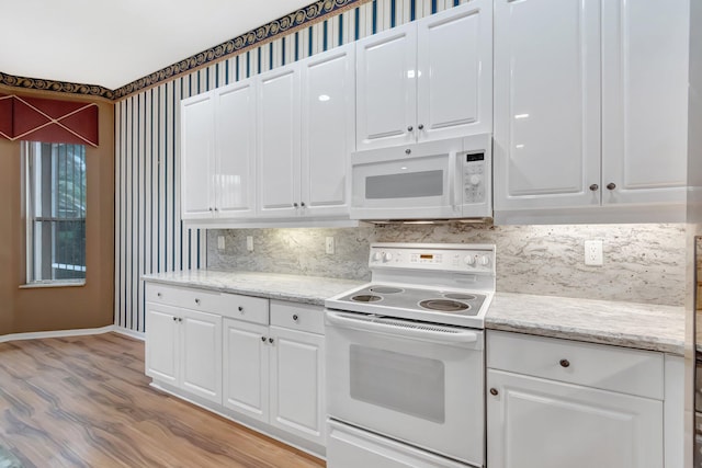 kitchen featuring white appliances, baseboards, light wood-type flooring, backsplash, and white cabinetry