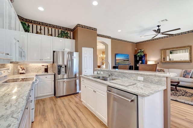 kitchen with appliances with stainless steel finishes, a sink, a ceiling fan, light wood finished floors, and recessed lighting