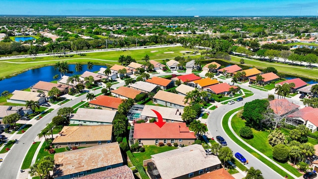 drone / aerial view featuring view of golf course, a water view, and a residential view