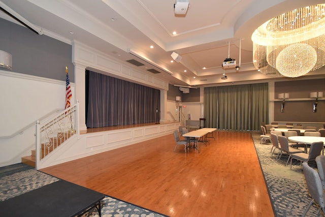 interior space with recessed lighting, a raised ceiling, an inviting chandelier, and wood finished floors