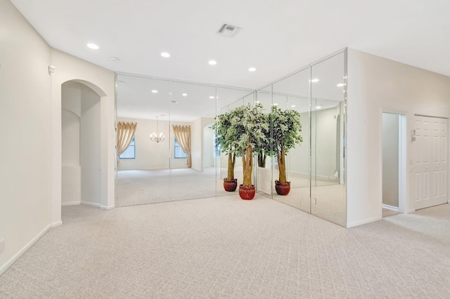 below grade area featuring carpet floors, recessed lighting, baseboards, a chandelier, and arched walkways