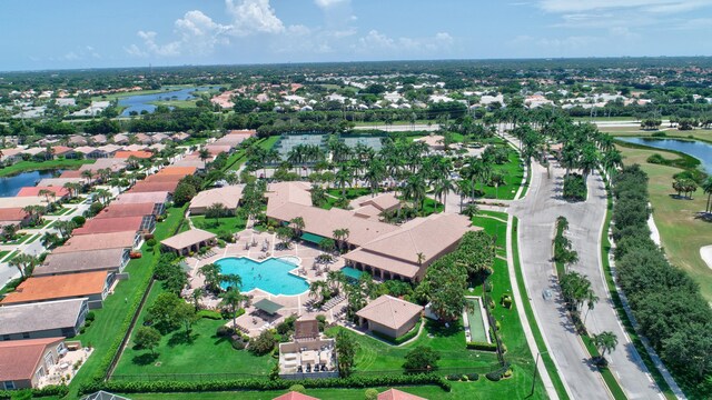 view of property location featuring a pool, a large body of water, and nearby suburban area